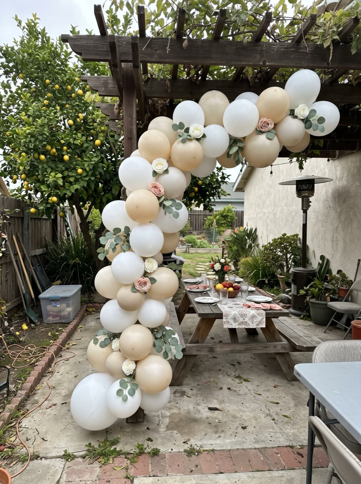White and champagne arch with roses and eucalyptus over a brunch table
