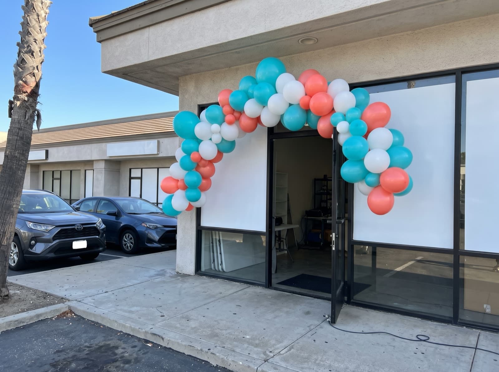 Large balloon arch over a small shop entrance