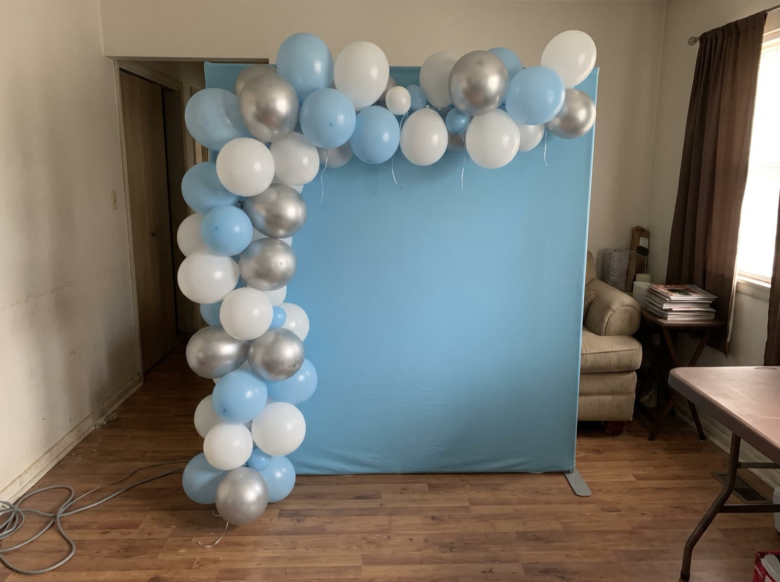 Square sky blue backdrop with a garland up one side