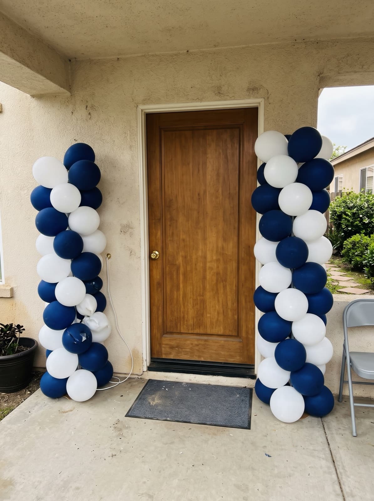 Pair of navy and white spiral balloon columns at a front door