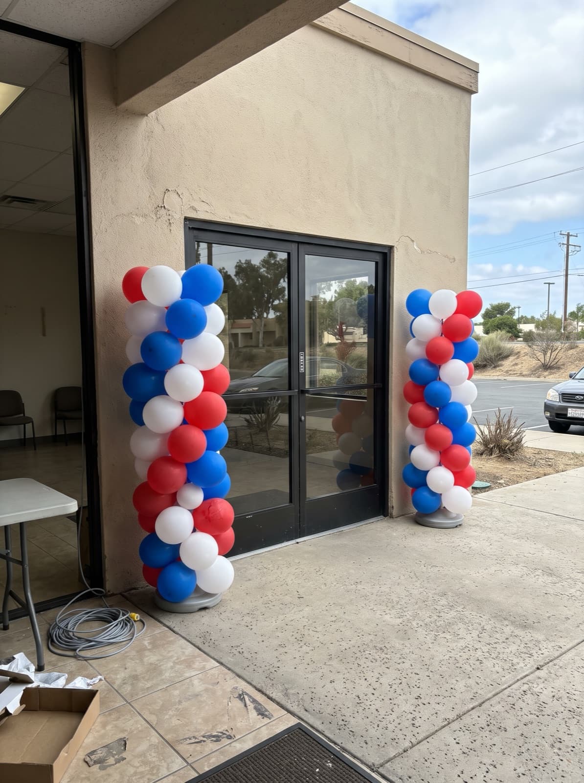Red, white and blue spiral balloon columns at a clubhouse entrance