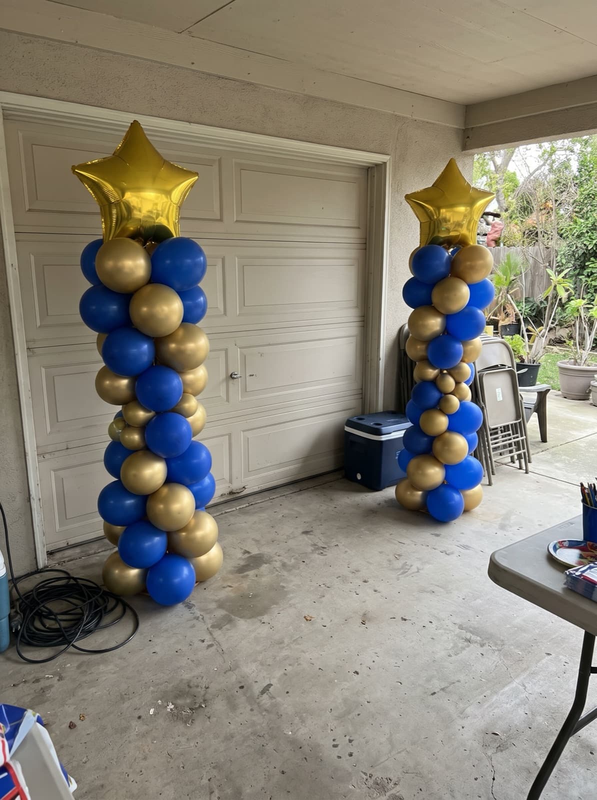 Blue and gold balloon columns with star toppers for a graduation