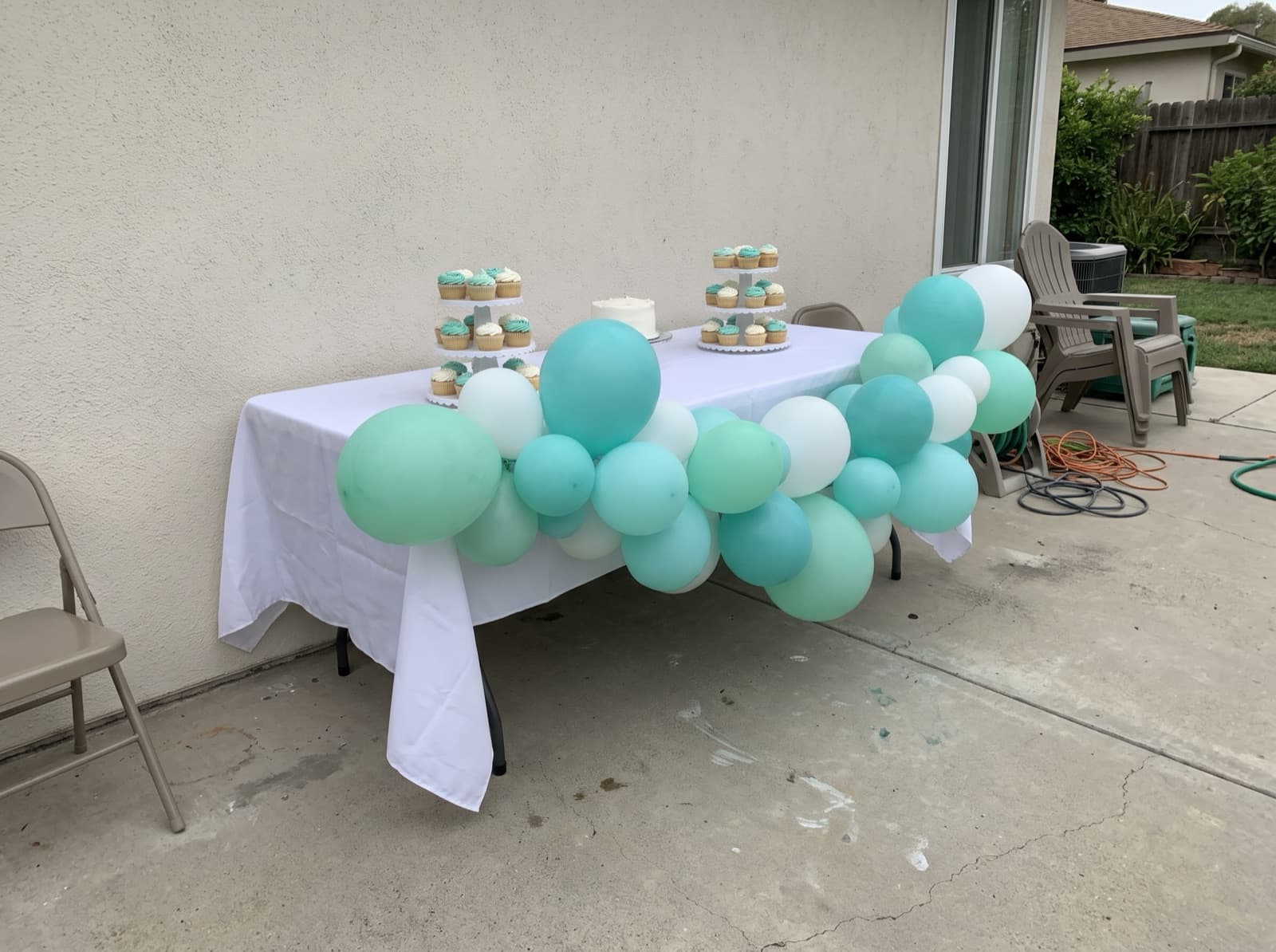 Balloon garland draped along the front of a cake table