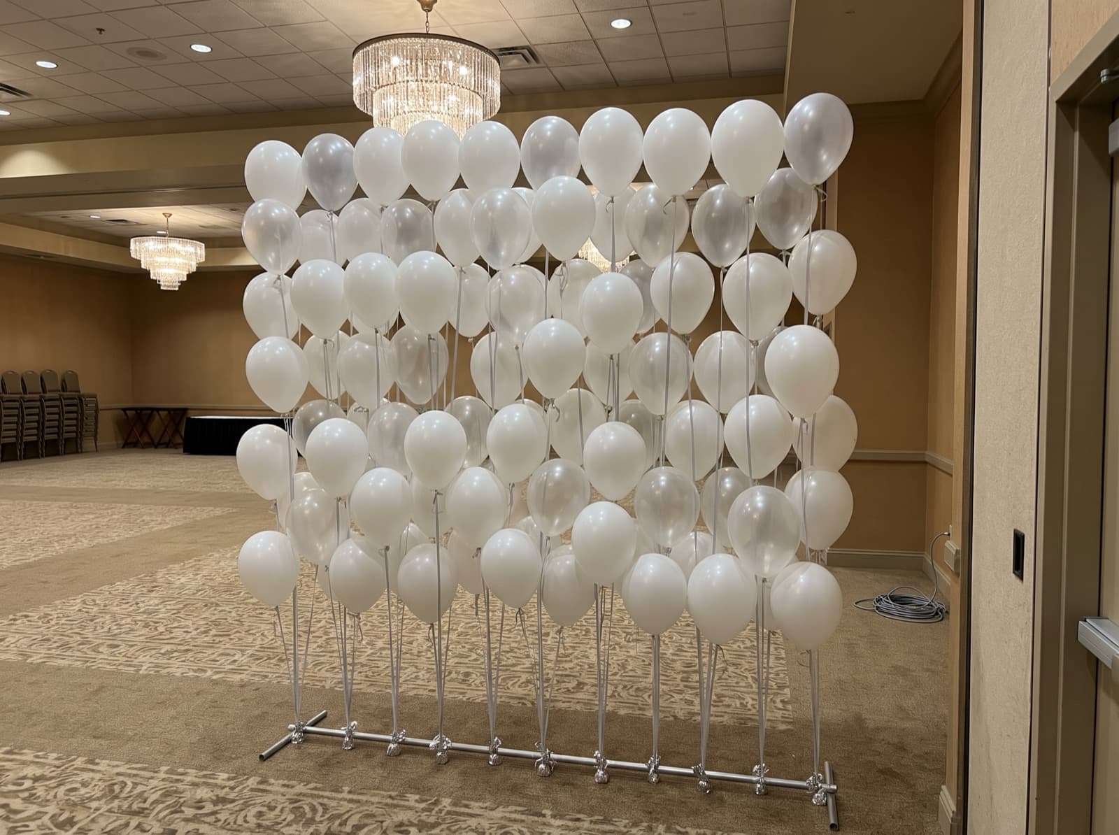 Floating helium balloon wall with ribbons in a ballroom