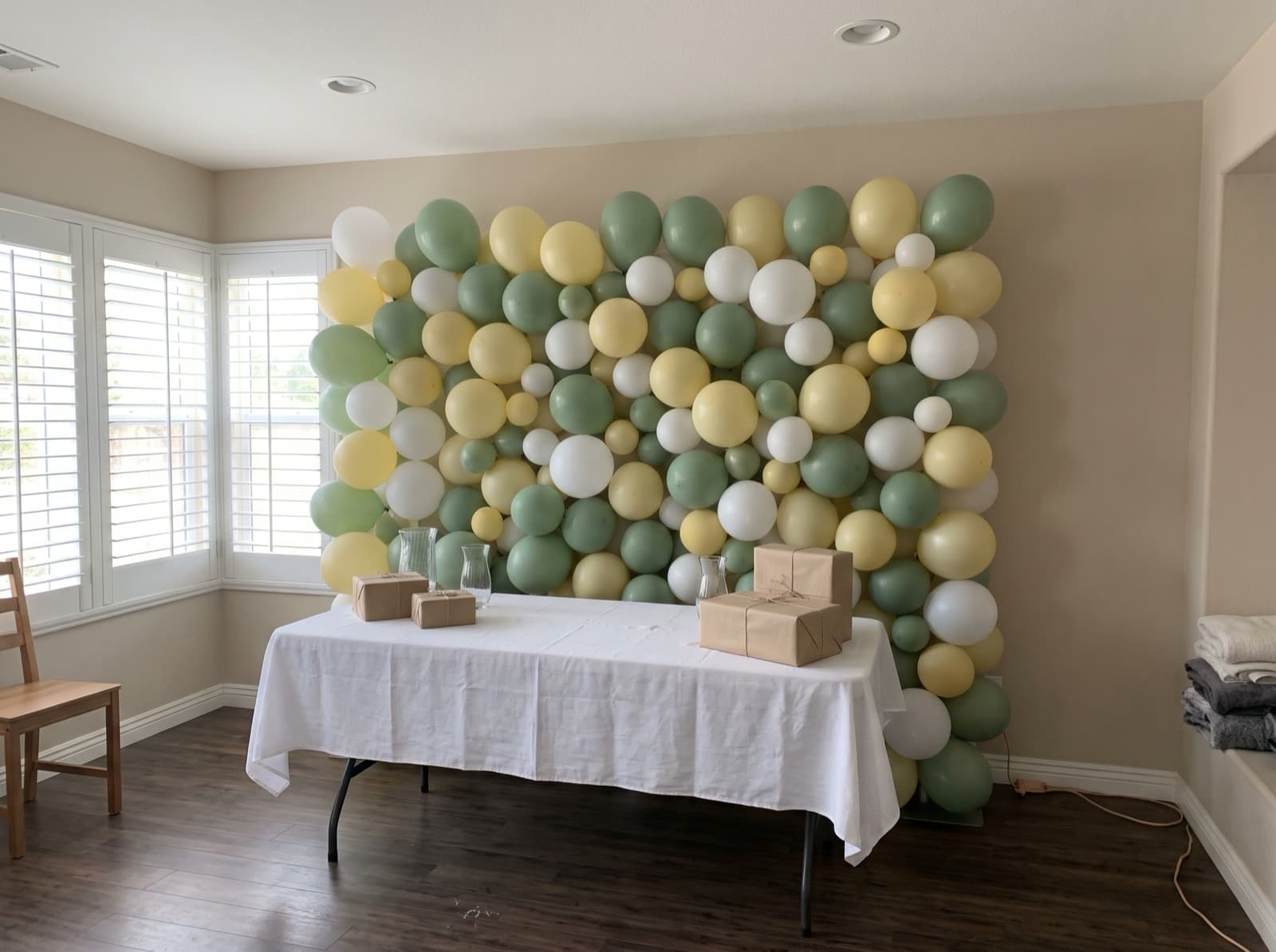 Sage, butter yellow and white balloon wall for a baby shower